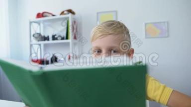 疲倦的小男孩阅读教科书，把头放在桌子上，教育理念